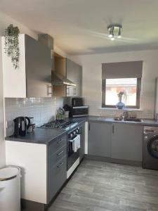 una cucina con lavello e fornello forno superiore di 2 Bed Entire Upper Cottage Flat in Central Glasgow a Glasgow