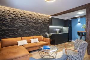 a living room with a couch and a brick wall at Loft Garmendia con PlayStation in Santander