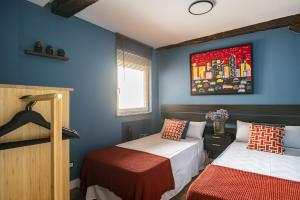 two beds in a room with blue walls at Loft Garmendia con PlayStation in Santander