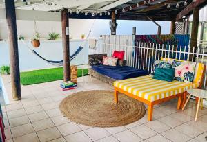 a patio with a couch and a chair and a rug at The Espy Hostel in Cairns