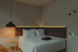 a bed with a bag sitting on top of it at The Click Clack Hotel Bogotá in Bogotá