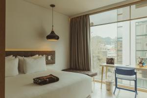 a hotel room with a bed and a large window at The Click Clack Hotel Bogotá in Bogotá