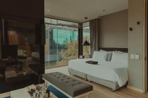 a bedroom with a bed and a living room at The Click Clack Hotel Bogotá in Bogotá