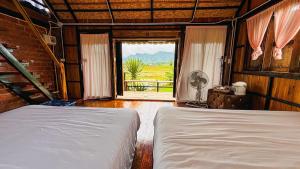 เตียงในห้องที่ DeeTorJai FarmStay Nan ดีต่อใจ ฟาร์มสเตย์ น่าน โดยเจ้าของ
