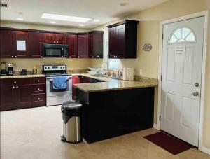 a kitchen with wooden cabinets and a white door at Tutul House in Tampa
