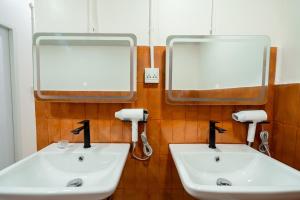 two sinks in a bathroom with two mirrors at Yimwhan House 02, Ayutthaya old town in Phra Nakhon Si Ayutthaya