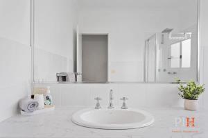 a white bathroom with a sink and a mirror at Spacious 4-Bd in Cowes sleeps 8 in Cowes +22 photos