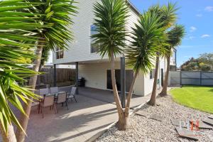a house with palm trees in front of it at Spacious 4-Bd in Cowes sleeps 8 in Cowes