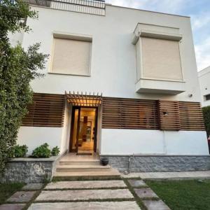 a white house with a front door and windows at Elegant 3-Floor Villa with Private Garden in Westown, SODIC Beverly Hills, Sheikh Zayed in Sheikh Zayed