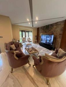 a large living room with couches and a tv at Elegant 3-Floor Villa with Private Garden in Westown, SODIC Beverly Hills, Sheikh Zayed in Sheikh Zayed +32 photos