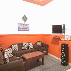 a living room with a couch and a tv at Villa Cahaya 2 Guci Mitra RedDoorz in Tuwel