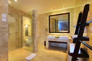 Un baño con dos lavabos, una ducha y un espejo. en Vacha 1 BR Ocean Suite View ZN223, en Nusa Dua