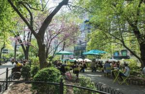 ニューヨークにあるLavish Downtown Manhattan Oasis in Union Squareの公園内の席に座る人々