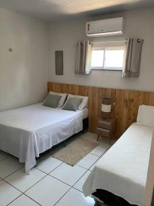 une chambre avec deux lits et une fenêtre dans l'établissement Flecheirasapê, à Flecheiras