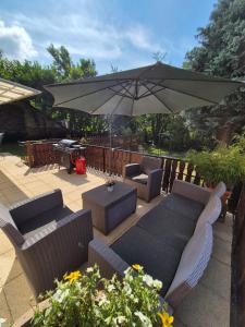 eine Terrasse mit einem Sonnenschirm, Stühlen und einem Tisch in der Unterkunft Ferienhaus Dhrontal in Neumagen-Dhron