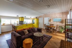 a living room with a couch and a table and a kitchen at Pušyno apartamentai in Druskininkai