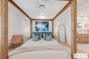a bedroom with a large bed with blue pillows at Bargara Coastal Luxe Aircon, Outside Pet, Sleeps 8 in Bargara