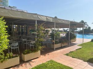 a restaurant with tables and chairs under a canopy at Apartamento playamar in Torremolinos