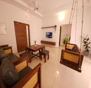 a living room with a couch and a swing at Thulasi Avenue Inn in Pollāchi