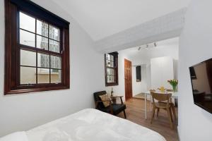 a bedroom with a bed and a dining room with a table at Cosy Little Venice Pied-à-Terre by MoreThanStays in London