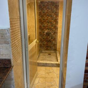 a shower with a glass door and a brick wall at Studio near airport in Cairo +92 photos