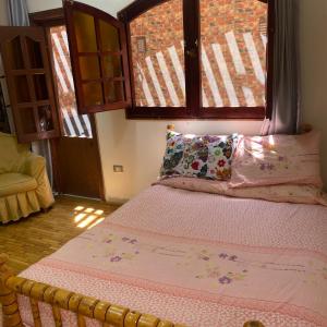 un lit dans une chambre avec une grande fenêtre dans l'établissement Studio near airport, au Caire