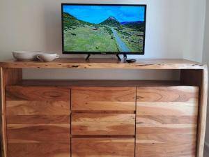 a television sitting on top of a wooden entertainment center at Regina di Cuori in La Maddalena