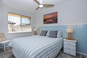 a bedroom with a bed and a ceiling fan at Bennett's Beach House in Hawks Nest +19 photos