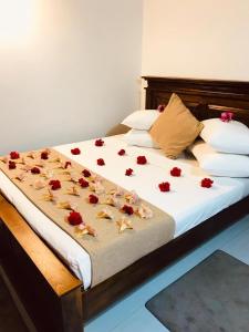 a bed with red rose petals on it at Stanley Villa One in Induruwa