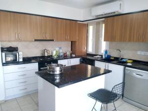 a kitchen with white cabinets and a black counter top at Apartment in Kyrenia City Center 2 in Temblos