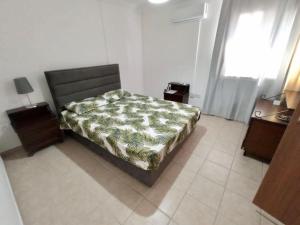 a bedroom with a bed and two tables and a window at Apartment in Kyrenia City Center 2 in Temblos