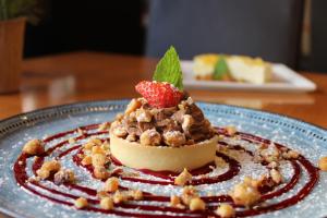 Un postre con una fresa en un plato azul. en The Old Woolstore Apartment Hotel, en Hobart 62 fotos más