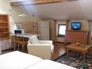 cocina y sala de estar con mesa y nevera en America Apartments, en Trento