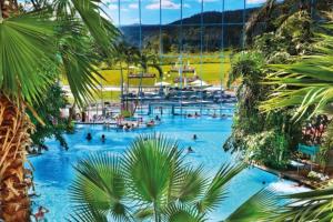 Una piscina en un resort con gente en ella. en Loft mit Whirlpool & Fass-Sauna im Schwarzwald, en Neuenbach