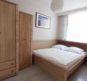 里沃Apartament Zachodni Rewal的一间卧室，里面有一张床和一扇大窗户。