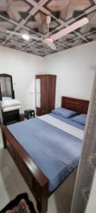 a bedroom with a bed with blue sheets and a ceiling at Yala Reach Hotel in Tissamaharama