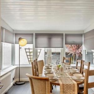 a dining room with a long table and chairs at Ty Llwyd - Luxury holiday home sleeping 8, Hot Tub available in Llandudno