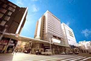 a tall building on a city street with a crosswalk at Hiroshima Washington Hotel in Hiroshima