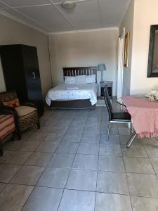 a bedroom with a bed and a table and chairs at Chameleon in Kirkwood