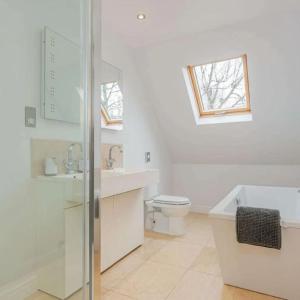 a bathroom with a toilet and a sink and a window at Cysgod Y Dyffryn - Luxury holiday cottage sleeping 8, Hot Tub available in Pen-y-groes