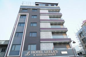德瓦尔卡Hotel Leela's的一座前面有标志的高楼