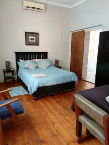 a bedroom with a bed and a wooden floor at Chameleon in Kirkwood