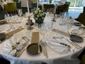 ein Tisch mit einer weißen Tischdecke, Tellern und Besteck in der Unterkunft Møn Golf Resort - Hotel Præstekilde in Stege
