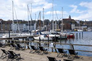 a group of chairs on a dock with boats in the water at Sunday Hotel des Nordens in Flensburg +72 photos