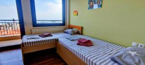 a small bedroom with two beds and a window at Olympus Panorama Luxury Apartment in Litochoro