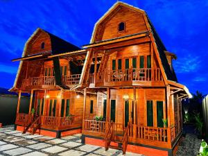 a wooden house with balconies on the side of it at Noerbaya House Bukittinggi in Bukittinggi