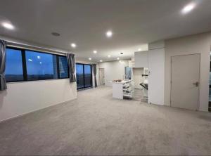 a large kitchen with white walls and a large window at 北岸小屋 in Auckland