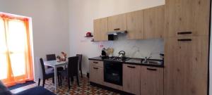 a kitchen with a sink and a table with chairs at Charming Townhouse - Steps from Waterfront in Marsaxlokk