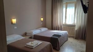 a hotel room with two beds and a window at B&B Monté in Montesilvano