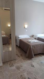 a hotel room with two beds and a mirror at B&B Monté in Montesilvano